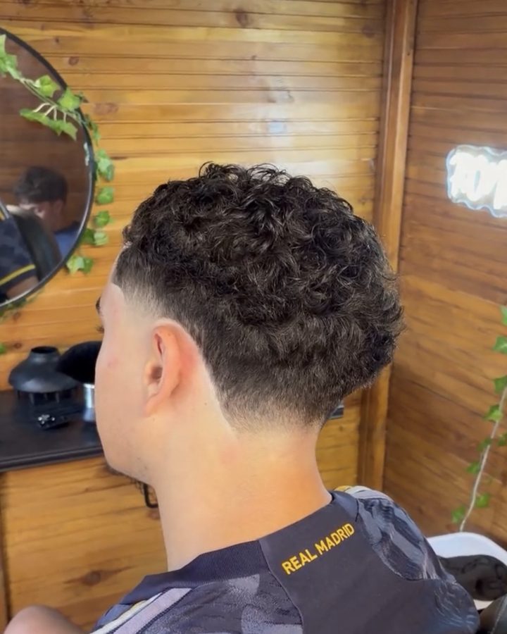Dégradé bas sur cheveux bouclés réalisé au salon, vu de dos