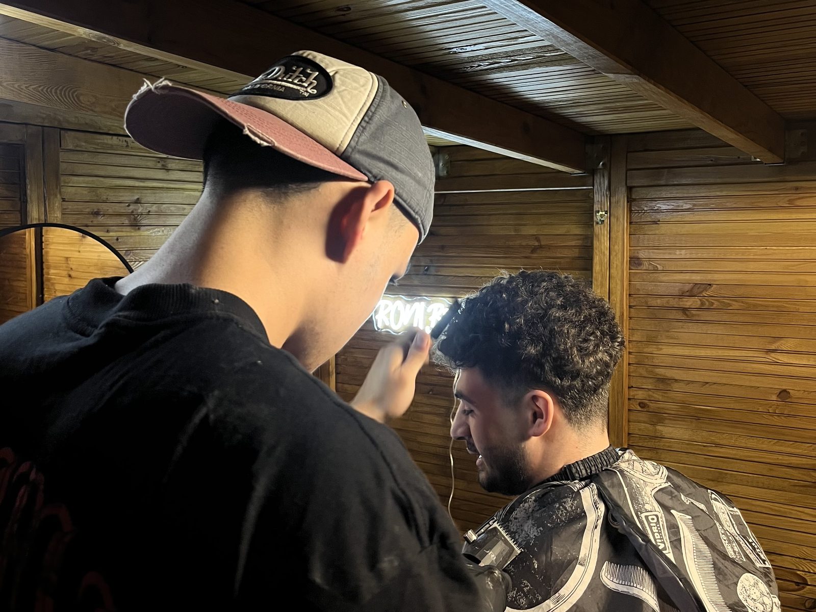 Roni en train de couper dans le salon en bois